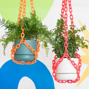 Two hanging planters with colorful chains against a colorful abstract background